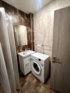 ein Badezimmer mit einer Waschmaschine und einem Waschbecken in der Unterkunft Tsakhkadzor Kechi House Цахкадзор Кечи in Zaghkadsor
