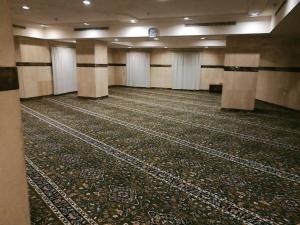 a large room with a carpeted floor and a clock at فندق منار التوحيد 1 in Makkah
