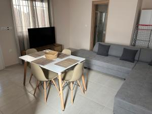 a living room with a table and chairs and a couch at Zoumpouli Village in Spartià