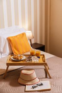 una bandeja de comida y dos vasos de zumo de naranja en una cama en Apironero Plouti House en Ploutí