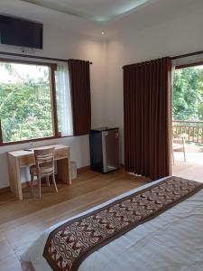 1 dormitorio con cama, escritorio y mesa en Karma House en Ubud