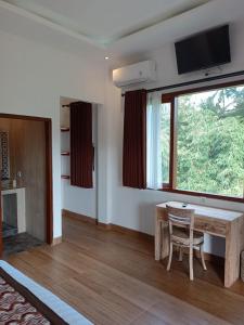 sala de estar con mesa de madera y ventana en Karma House en Ubud