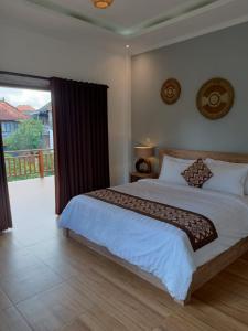 a bedroom with a large bed and a large window at Karma House in Ubud