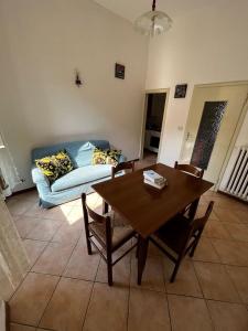 een woonkamer met een tafel en een bank bij Appartamento centrale con vista su montagna in Porretta Terme