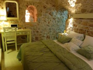 a bedroom with a bed and a table and a desk at St. George Sykoussis Traditional Residence in Ágios Geórgios Sykoúsis