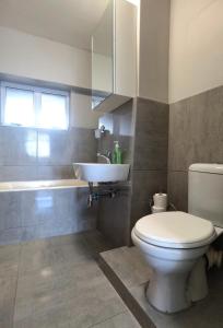 Un baño con un inodoro blanco y un lavabo. en Lela Holiday Apartments, en Durban