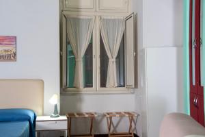 ナポリにあるPalazzo Carafa della Spina - Maison de Charmeの窓、ベッド、テーブルが備わる客室です。