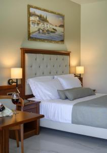 ゲオルギオポリスにあるVantaris Palaceのベッドルーム1室(ベッド1台、テーブル、ランプ2つ付)