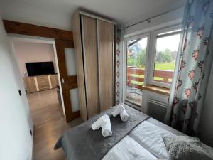 een slaapkamer met een bed met twee handdoeken erop bij Apartament Kameralny in Zakopane