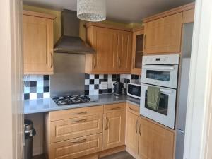 a kitchen with wooden cabinets and a stove top oven at Imperial way Ashford TN23 in Kent