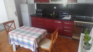 een keuken met een tafel, een wastafel en een fornuis bij Λευκό σπίτι in Ksamil