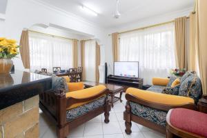 a living room with couches and a flat screen tv at B2 Royal Palm apartments - Mtwapa in Mtwapa