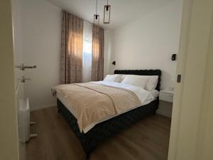 Un dormitorio con una cama grande con almohadas blancas. en La Casa Apartments, en Jagodina