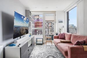 sala de estar con sofá y TV de pantalla plana en Peachy Stays 2-Bedroom Amazing Flat With Balcony, en Londres