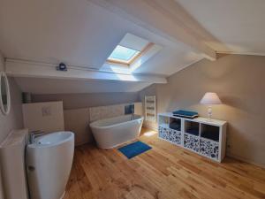 een badkamer met een wastafel, een bad en een dakraam bij Petit Beaucours in Sanary-sur-Mer