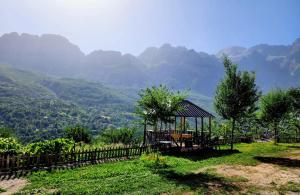 a gazebo on a hill with mountains in the background at Mountain Vista Guesthouse Shkafi in Shkodër