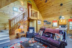 una sala de estar con sofá y escaleras en una cabaña en Sevierville Cabin with Deck, Pool and Lake Access!, en Sevierville