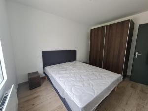 a bedroom with a bed and a wooden cabinet at Gîtes du Grand Air in Saint-Michel-en-lʼHerm +5 photos