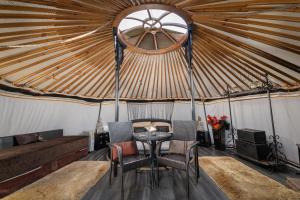 a room with a table and chairs in a yurt at Lincoln Yurts in Lincoln