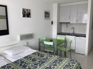 a bedroom with a bed and a table and a kitchen at Casa climatizada in Playa Fañabe
