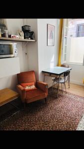 a living room with a table and a couch and a table and chair at Bulles Champagne Troyes Bouchon in Troyes