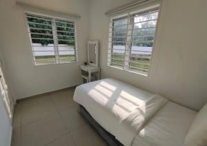 1 dormitorio blanco con 1 cama y 2 ventanas en KITAKAYA Homestay Templer Park Rawang - 15 Pax, en Rawang