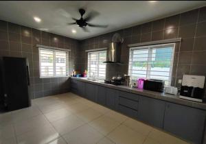 cocina grande con ventilador de techo en una habitación en KITAKAYA Homestay Templer Park Rawang - 15 Pax, en Rawang