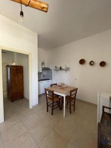 uma cozinha com mesa e cadeiras num quarto em Masseria Scianne em Sant'Isidoro