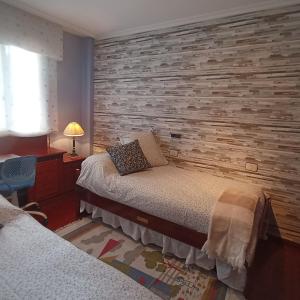 a bedroom with two beds and a brick wall at MAR AVILLA ESPECTACULAR RIA DE VIGO con PARKING PLAYA in Moaña