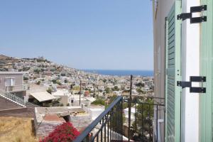 a view of the city from the balcony of a building at Απεριόριστη Θέα δίπλα στην πόλη in Ano Syros