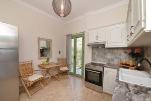 a kitchen with white cabinets and a table with chairs at Απεριόριστη Θέα δίπλα στην πόλη in Ano Syros
