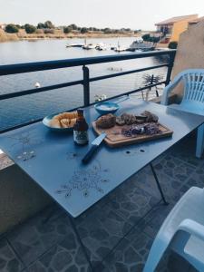 a table with a plate of food and a bottle of beer at Appartement coup de coeur les pieds dans l'eau in Le Barcarès