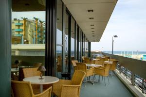 a restaurant with tables and chairs on a balcony at Hotel Nord Est in Rimini