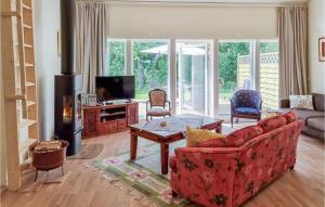 sala de estar con sofá rojo y chimenea en Stunning Home In Tvrred With Kitchen en Alhammar