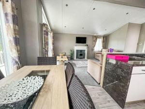 cocina y comedor con mesa y sillas en Stunning Lodge With Decking At Oaklands Holiday Park In Essex Ref 39017rw en Clacton-on-Sea