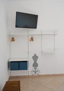 ein Wohnzimmer mit einem TV an einer weißen Wand in der Unterkunft La Petra in Vico Equense