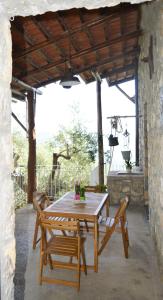 einen Holztisch und Stühle auf einer Terrasse in der Unterkunft La Petra in Vico Equense