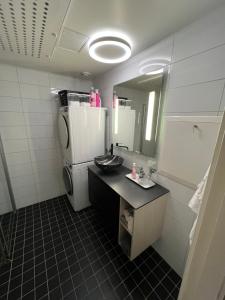 een kleine badkamer met een wastafel en een koelkast bij Moderne og romslig leilighet, 2 soverom, sentralt. in Trondheim