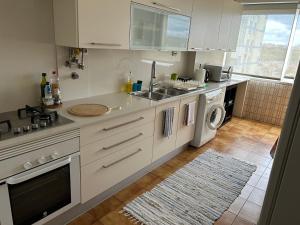a kitchen with a sink and a washing machine at Boa Vista Apartamento in Odivelas