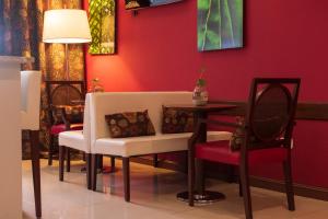 1412 Hotel Boutique في روزاريو: غرفة طعام بجدران حمراء وطاولة وكراسي