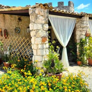 a garden with flowers in front of a house at Torre Rodosta in Modica