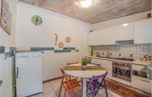 La cuisine est équipée d'une table, de chaises et d'un réfrigérateur. dans l'établissement Beautiful Home In Villapiana With Wifi, à Villapiana