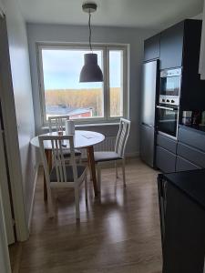 een keuken met een tafel en stoelen en een raam bij Rytitornit Apartment A18 in Kemi