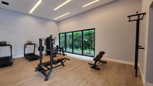 a gym with treadmills and exercise equipment and a large window at Loft Confortável e Luxuoso ao lado do Shopping CG. in Campo Grande