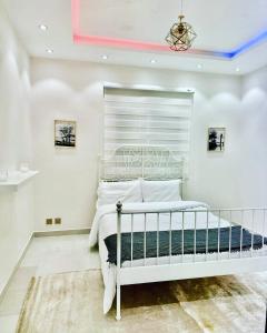 a bedroom with a white bed in a room at شاليه ضفاف - Difaf Chalet - فخم وجديد وفاخر in Jeddah