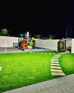 - un parc avec une aire de jeux en soirée avec de l'herbe verte dans l'établissement شاليه ضفاف - Difaf Chalet - فخم وجديد وفاخر, à Djeddah