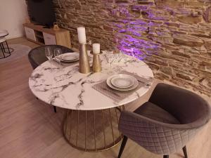 - une table à manger avec une table et des chaises en marbre dans l'établissement Loft blanc (baignoire balnéo et sauna), à Trois-Ponts