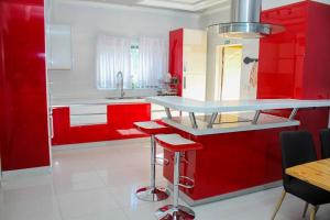a red kitchen with a counter and red cabinets at SteyMorr Guesthouse in Maun