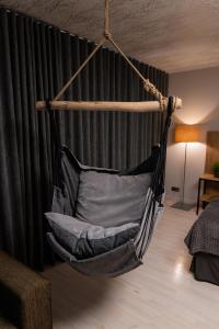 a hammock hanging in a room with a bed at Kalniem Pāri Guest House 