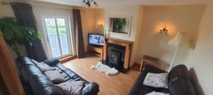 uma sala de estar com um sofá de couro e uma lareira em Carrick-On-Shannon Townhouse Accommodation - Room only em Carrick on Shannon